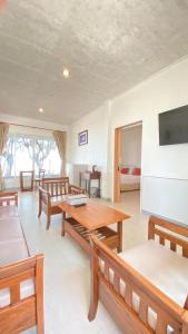 a living room with a table and benches and a bed at Laemsing Natural Beach Resort in Ban Pak Nam