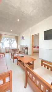 sala de estar con mesa, bancos y cama en Laemsing Natural Beach Resort en Ban Pak Nam