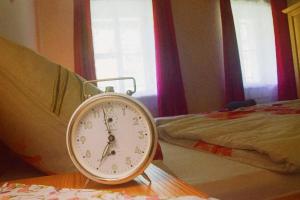 a alarm clock sitting on a table next to a bed at Ferienhaus Masser in Mainsdorf +32 photos