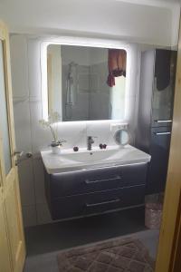y baño con lavabo blanco y espejo. en Ferienhaus Masser, 