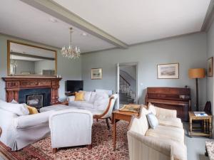 a living room with white furniture and a fireplace at Refurbished Highland Lodge in Spectacular Scenery in Pitlochry