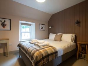 a bedroom with a bed with towels on it at Refurbished Highland Lodge in Spectacular Scenery in Pitlochry