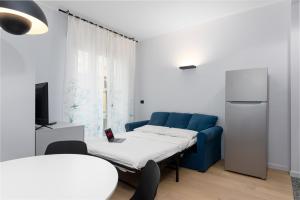 uma sala de estar com um sofá azul e uma televisão em [Centro Torino] Elegante e Moderno Bilocale em Turim