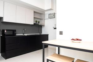 una cocina con armarios en blanco y negro y una encimera en Stay @ NOVO Ampang en Kuala Lumpur