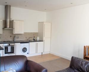 a living room with a couch and a kitchen at Thornhill Apartment in Sunderland