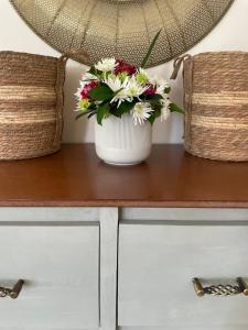 un jarrón de flores sentado sobre una mesa en Ambré Guesthouse, en Francistown