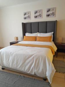 a bedroom with a large bed with orange pillows at Ambré Guesthouse in Francistown