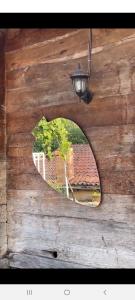 een spiegel op een houten muur met een raam bij Zaalis wine cellar in Vani