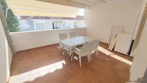 una mesa y sillas en el balcón de una casa en Islantilla-Apartamento con piscina y garaje en primera línea de playa, en Isla Cristina