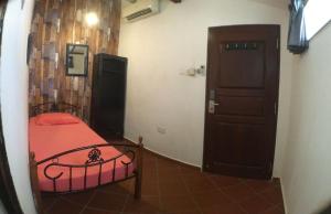 een kleine kamer met een bed en een deur bij New Great Shanghai Female Hostel in George Town