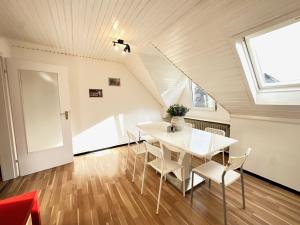 een witte eetkamer met een witte tafel en stoelen bij Spacious & Cozy Apartments in Krefeld
