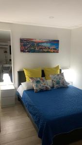 een slaapkamer met een bed met blauwe lakens en gele kussens bij La casetta ai Gradoni di Chiaia in Napels
