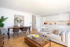 - un salon avec un canapé blanc et une table dans l'établissement Malagueta Beach Front Luxury Apartment by Rent Me, à Malaga