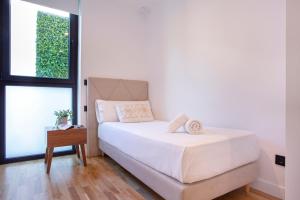 - une chambre blanche avec un lit et une fenêtre dans l'établissement Malagueta Beach Front Luxury Apartment by Rent Me, à Malaga