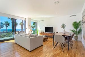 - un salon avec un canapé, une table et une salle à manger dans l'établissement Malagueta Beach Front Luxury Apartment by Rent Me, à Malaga