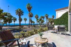 d'une terrasse avec vue sur la plage et les palmiers. dans l'établissement Malagueta Beach Front Luxury Apartment by Rent Me, à Malaga