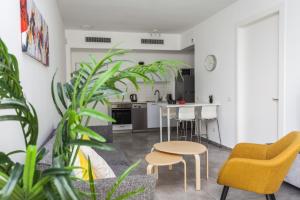 ein Wohnzimmer mit einem Tisch, Stühlen und Pflanzen in der Unterkunft Arenda Tel Aviv Apartments by the Beach with shelter in Tel Aviv