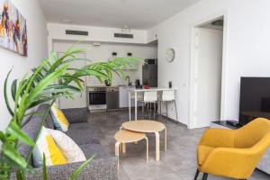 ein Wohnzimmer mit einem Sofa, einem Tisch und Stühlen in der Unterkunft Arenda Tel Aviv Apartments by the Beach with shelter in Tel Aviv