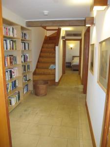 a hallway with a staircase in a room with books at Beautiful Award-Winning Rural Home in Dolphinton