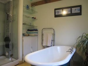 Beautiful Award-Winning Rural Home في Dolphinton: حمام مع حوض أبيض ومغسلة