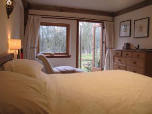 Beautiful Award-Winning Rural Home في Dolphinton: غرفة نوم بسرير كبير ونافذة