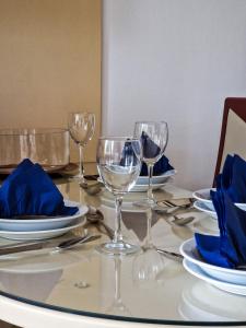 a table with wine glasses and blue napkins on it at Boulevard Apartments in Kumanovo