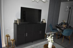 ein Wohnzimmer mit einem TV auf einem Schrank in der Unterkunft R V Properties Luxury Suites 21 & 23 in Hemel Hempstead