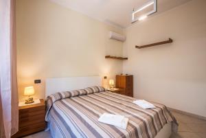 ein Schlafzimmer mit einem Bett mit einer gestreiften Decke in der Unterkunft Dimora di Sofia in Siena