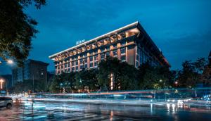 un bâtiment la nuit avec un bus devant lui dans l'établissement Hilton Xi'an, à Xi'an