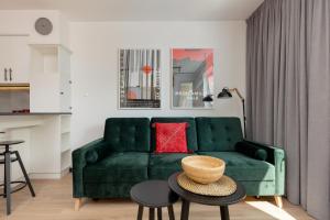 sala de estar con sofá verde y mesa en Warsaw Piaseczno Stylish Apartment with Parking by Renters, en Piaseczno