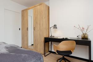 1 dormitorio con escritorio, cama y silla en Warsaw Piaseczno Stylish Apartment with Parking by Renters, en Piaseczno