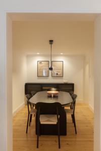 uma sala de jantar com mesa e cadeiras em FLH Alluring Design Apartment S Bento em Lisboa