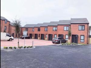 a parking lot in front of a brick building at Swansea city center flat parking in Swansea