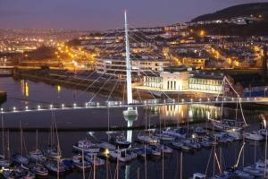 a group of boats docked in a marina at night at Swansea city center flat parking in Swansea