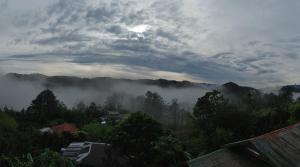 a view of a foggy valley with trees and mountains at Cam-Jhao's Homestay in Sagada