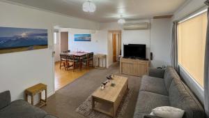 un salon avec un canapé et une table dans l'établissement High Country Cottage, à Twizel