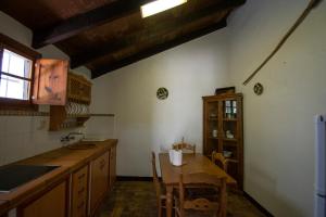 a kitchen with a table and a sink and a counter at Casa rural el Carmen in Prado del Rey