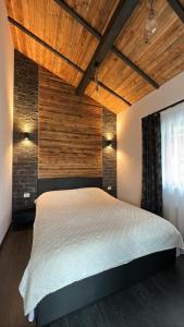 a bedroom with a large bed with a wooden ceiling at Tiny House Todireni in Vatra Dornei