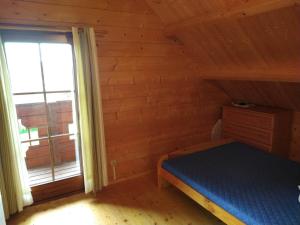 um pequeno quarto com uma cama e uma janela em Domek nad jeziorem Rożnowskim - Gródek Nad Dunajcem em Gródek Nad Dunajcem
