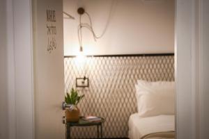um quarto com uma cama e uma luz na parede em The Carmel House - Aparthotel in Kerem Hateimanim By Sea N' Rent em Tel Aviv