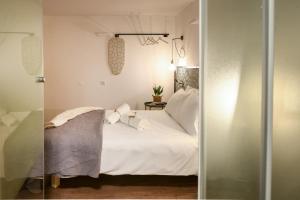 um quarto com uma cama branca e almofadas brancas em The Carmel House - Aparthotel in Kerem Hateimanim By Sea N' Rent em Tel Aviv