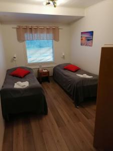 a bedroom with two beds and a window at Hostel Tikka in Rovaniemi