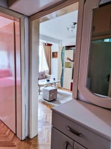1 dormitorio con espejo grande y sala de estar en Boulevard Apartments, en Kumanovo