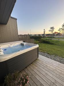 uma banheira de hidromassagem num deque com vista para um campo em Nytt og flott hus i Haugesund 