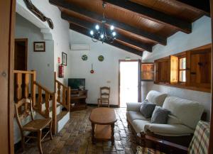 uma sala de estar com um sofá e uma mesa em Casa rural el Carmen em Prado del Rey