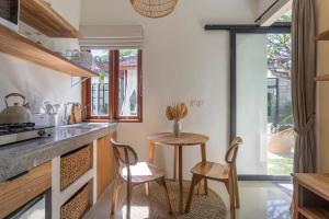 a kitchen with a table and two chairs and a counter at Designer Studio Emy Sanur in Sanur
