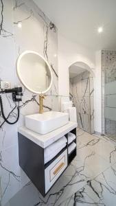 a bathroom with a sink and a mirror at Le Moulin d'Orgemont, hébergements & restaurants Argenteuil in Argenteuil +18 photos