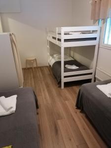 a room with two bunk beds and a wooden floor at Hostel Tikka in Rovaniemi