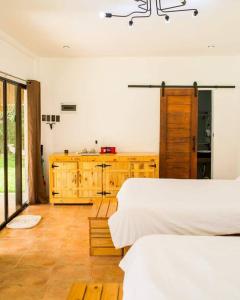 a bedroom with two beds and a wooden cabinet at Entire farm place w/ 2 casitas & dipping pool in Lubo