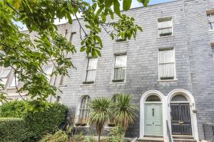 プリマスにあるPlymouth Central Apartmentsの緑の扉のある灰色のレンガ造りの家